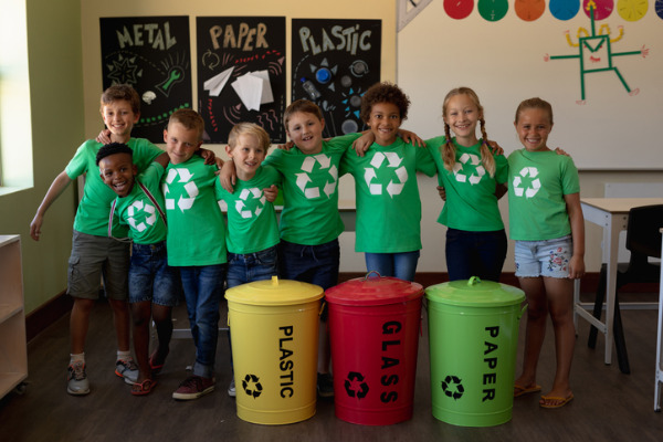 Group of schoolchildren doing recycling in class
